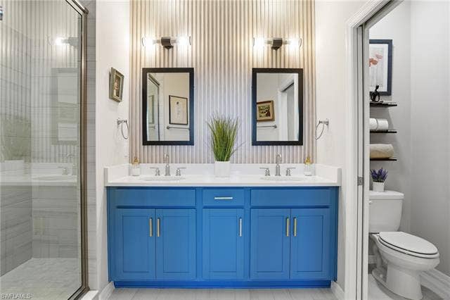 11861 Venetian Lagoon Dr, #203, Fort Myers, FL 33913 Bathroom featuring double vanity and a shower stall