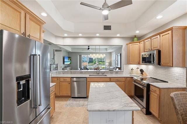 19620 Marino Lake Cir, #2802, Miromar Lakes, FL 33913 Kitchen with stainless steel appliances, a raised ceiling, ceiling fan, light wood finish cabinetry, and recessed lighting