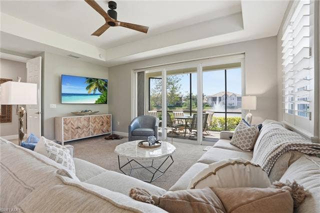 19620 Marino Lake Cir, #2802, Miromar Lakes, FL 33913 Living area featuring a raised ceiling, carpet flooring, and a ceiling fan