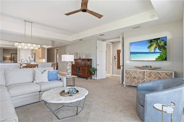 19620 Marino Lake Cir, #2802, Miromar Lakes, FL 33913 Living area with a ceiling fan, a tray ceiling, and light carpet