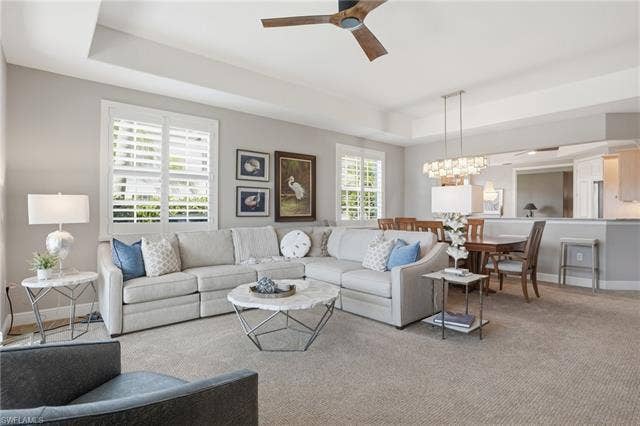 19620 Marino Lake Cir, #2802, Miromar Lakes, FL 33913 Carpeted living room featuring a tray ceiling, ceiling fan, and suspended lighting