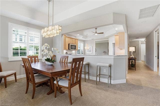 19620 Marino Lake Cir, #2802, Miromar Lakes, FL 33913 Dining space featuring a tray ceiling, light colored carpet, a ceiling fan, and recessed lighting