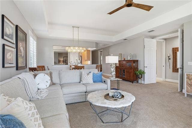 19620 Marino Lake Cir, #2802, Miromar Lakes, FL 33913 Living room featuring ceiling fan, a tray ceiling, light colored carpet, and hanging lights