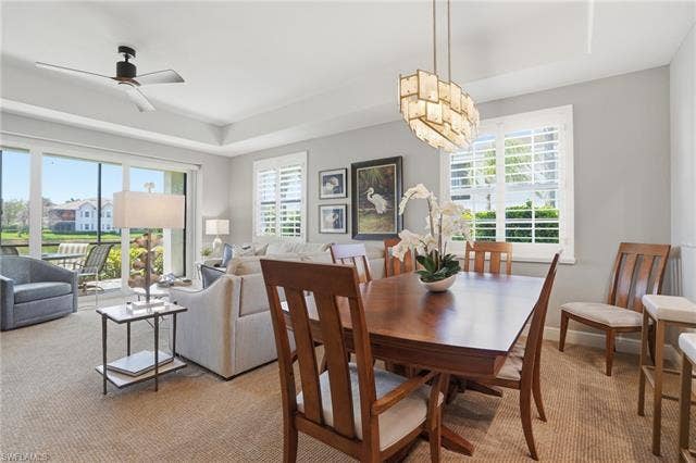 19620 Marino Lake Cir, #2802, Miromar Lakes, FL 33913 Dining space with carpet floors, a ceiling fan, and a tray ceiling