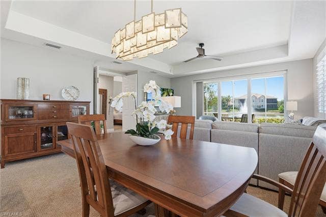 19620 Marino Lake Cir, #2802, Miromar Lakes, FL 33913 Dining area with a raised ceiling, light carpet, and ceiling fan