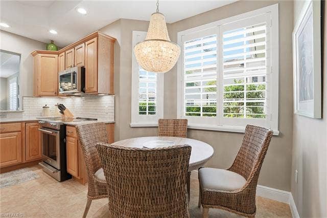19620 Marino Lake Cir, #2802, Miromar Lakes, FL 33913 Kitchen featuring stainless steel appliances, tasteful backsplash, hanging lights, light stone counters, and light tile patterned flooring