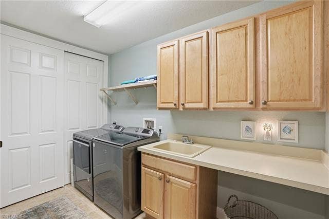 19620 Marino Lake Cir, #2802, Miromar Lakes, FL 33913 Laundry area featuring washer and dryer, cabinet space, and light tile patterned floors