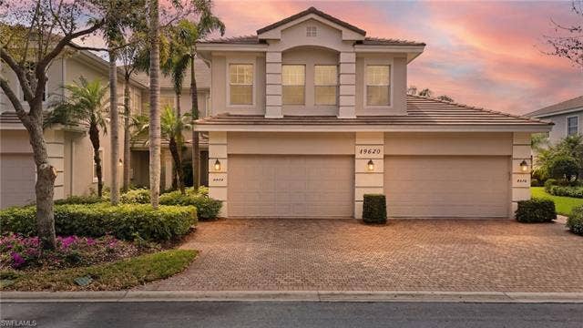 19620 Marino Lake Cir, #2802, Miromar Lakes, FL 33913 Mediterranean / spanish-style home with driveway, stucco siding, a tiled roof, and an attached garage