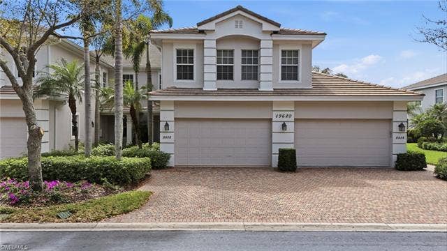 19620 Marino Lake Cir, #2802, Miromar Lakes, FL 33913 View of front of property featuring stucco siding, decorative driveway, a tiled roof, and a garage