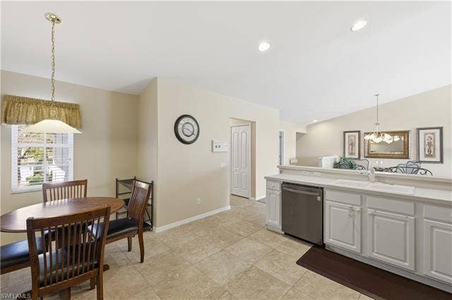 23541 Sandycreek Ter, #806, Estero, FL 34135 Kitchen featuring decorative light fixtures, dishwasher, light countertops, white cabinetry, and vaulted ceiling