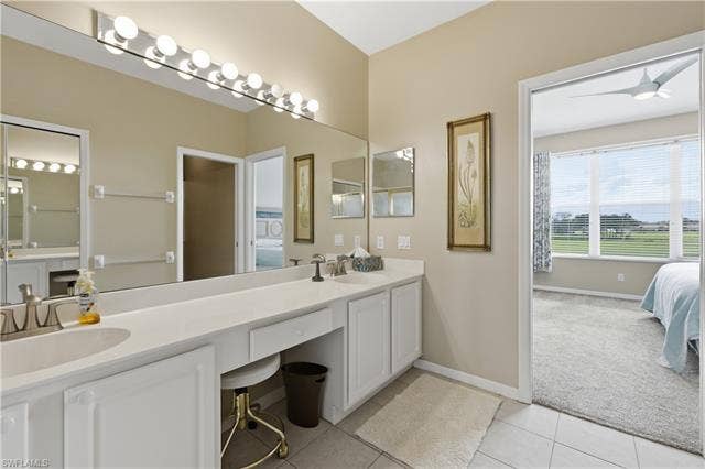 23541 Sandycreek Ter, #806, Estero, FL 34135 Bathroom featuring connected bathroom, double vanity, light colored carpet, light tile patterned floors, and ceiling fan
