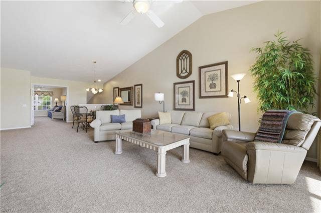 23541 Sandycreek Ter, #806, Estero, FL 34135 Carpeted living room with a ceiling fan, lofted ceiling, and a chandelier