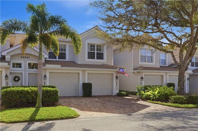 23541 Sandycreek Ter, #806, Estero, FL 34135 View of front facade featuring a garage, decorative driveway, a tile roof, and stucco siding
