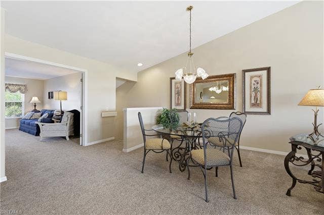 23541 Sandycreek Ter, #806, Estero, FL 34135 Dining room featuring light colored carpet, a chandelier, and vaulted ceiling
