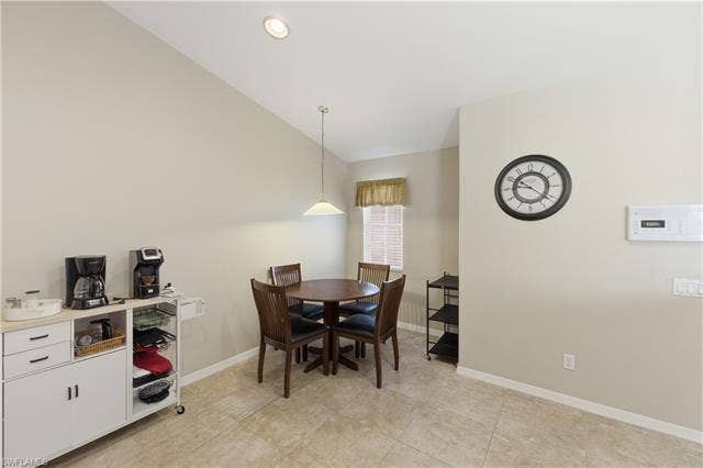 23541 Sandycreek Ter, #806, Estero, FL 34135 Dining space featuring baseboards and vaulted ceiling