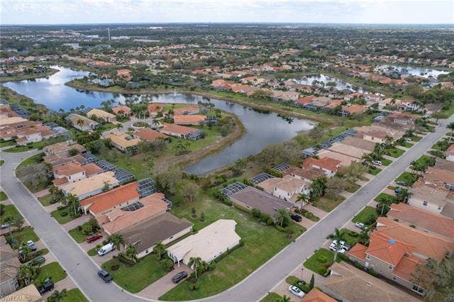 9071 Astonia Way, Estero, FL 33967 Aerial view of property and surrounding area featuring a large body of water and nearby suburban area