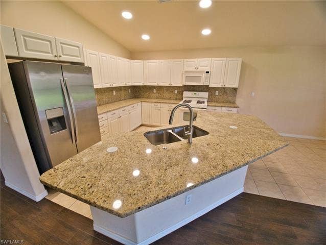 9071 Astonia Way, Estero, FL 33967 Kitchen featuring a large central island with a double basin sink and gooseneck faucet