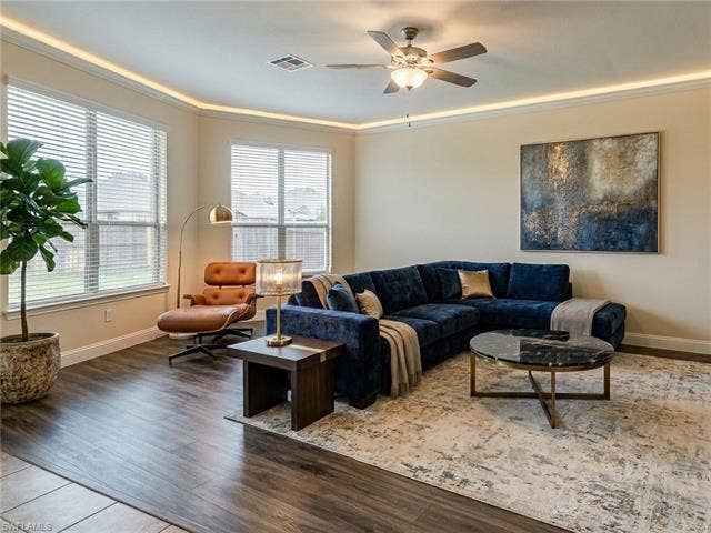 9071 Astonia Way, Estero, FL 33967 Living area featuring wood-finish flooring, a ceiling fan with integrated lighting, and crown molding with accent lighting
