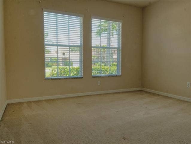 9071 Astonia Way, Estero, FL 33967 Two large windows with horizontal blinds and stone sills
