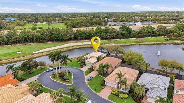 17801 Modena Rd, Miromar Lakes, FL 33913 Aerial view of residential area with a large body of water and a golf course
