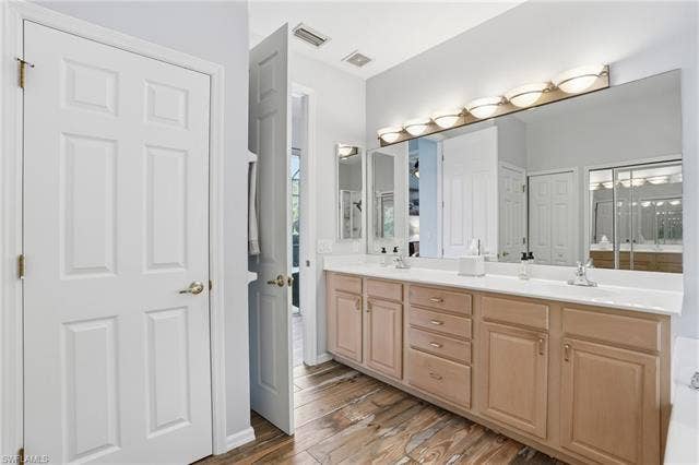 17801 Modena Rd, Miromar Lakes, FL 33913 Full bathroom with double vanity, light wood-style flooring, and a closet