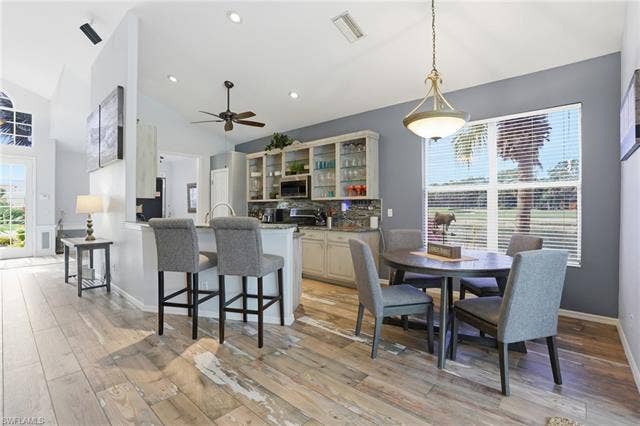 17801 Modena Rd, Miromar Lakes, FL 33913 Dining area featuring light wood-style floors, vaulted ceiling, recessed lighting, and ceiling fan