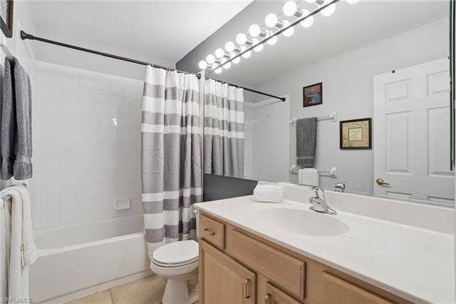 17801 Modena Rd, Miromar Lakes, FL 33913 Full bath with vanity, shower / bath combination with curtain, and light tile patterned floors