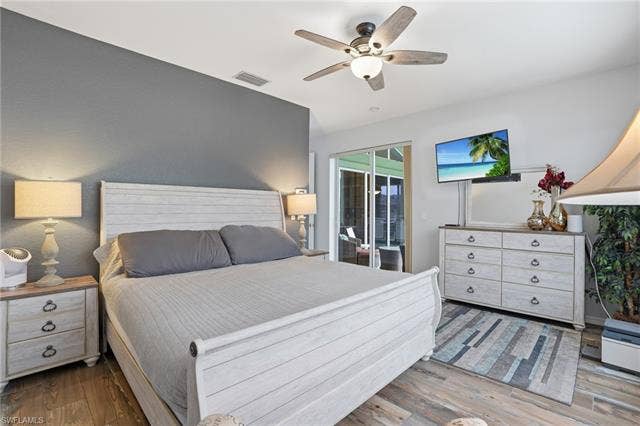 17801 Modena Rd, Miromar Lakes, FL 33913 Bedroom with wood finished floors, a ceiling fan, and access to exterior