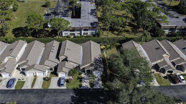 22161 Tallwood Ct, #706, Estero, FL 33928 Row of residential properties featuring attached garages, individual driveways, and sloped roofing