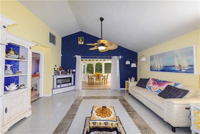 22161 Tallwood Ct, #706, Estero, FL 33928 Vaulted ceiling living area featuring tile flooring, a built-in electric fireplace, and an exposed beam ceiling fan