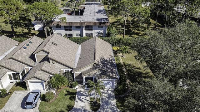 22161 Tallwood Ct, #706, Estero, FL 33928 Residential property featuring a shingle roof and a paved driveway