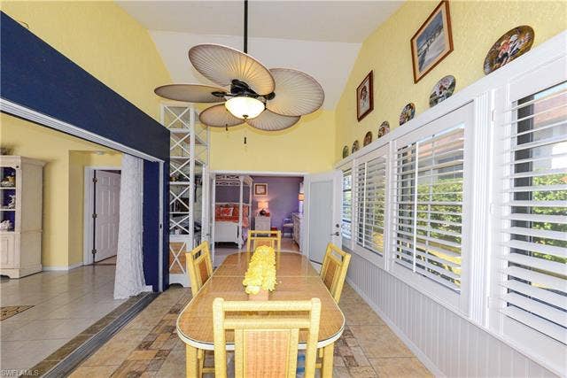 22161 Tallwood Ct, #706, Estero, FL 33928 Sunroom dining area featuring vaulted ceilings, a ceiling fan, and tile flooring