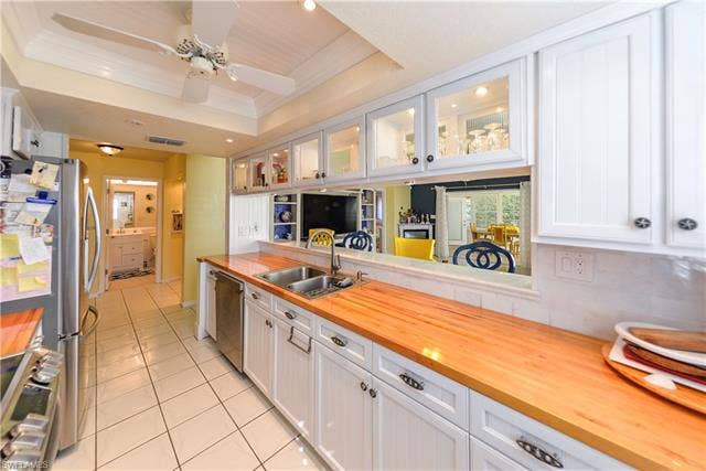 22161 Tallwood Ct, #706, Estero, FL 33928 Kitchen featuring white cabinetry, wood-finish countertops, and a dual-basin sink