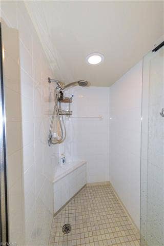 22161 Tallwood Ct, #706, Estero, FL 33928 Walk-in shower featuring white tile walls, a built-in corner bench, square mosaic floor tiles, a recessed ceiling light, and a handheld shower fixture