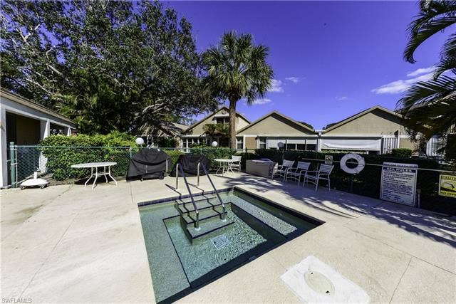 22161 Tallwood Ct, #706, Estero, FL 33928 Inviting outdoor spa with integrated steps, surrounded by concrete decking