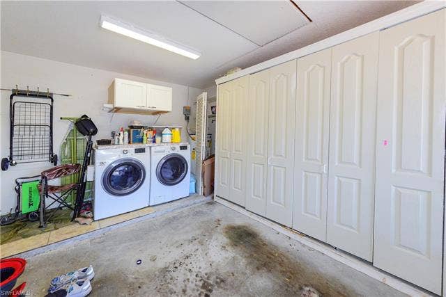 22161 Tallwood Ct, #706, Estero, FL 33928 Dedicated laundry area featuring a built-in countertop, upper cabinetry, and a full wall of integrated storage units