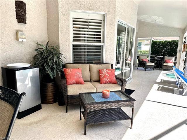 12654 Buttonbush Pl, Bonita Springs, FL 34135 Just outside the kitchen and living room is a sofa, cocktail table, and beverage fridge, for outdoor relaxing and entertaining.