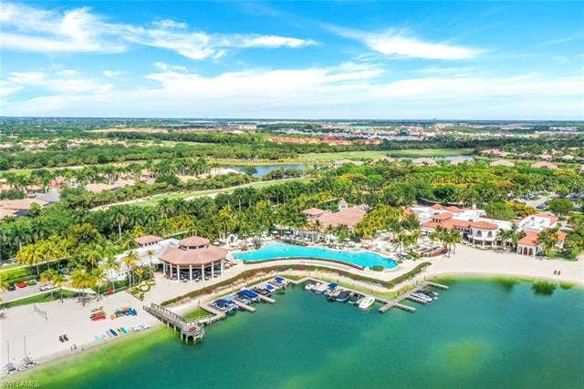 10060 Valiant Ct, #202, Miromar Lakes, FL 33913 Expansive resort-style complex featuring a large swimming pool, private beach area, boat docks, and surrounding green spaces