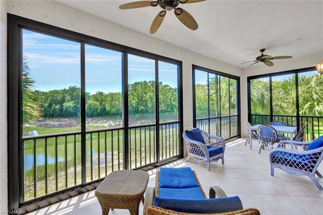 10060 Valiant Ct, #202, Miromar Lakes, FL 33913 Screened-in patio with tile flooring and multiple ceiling fans