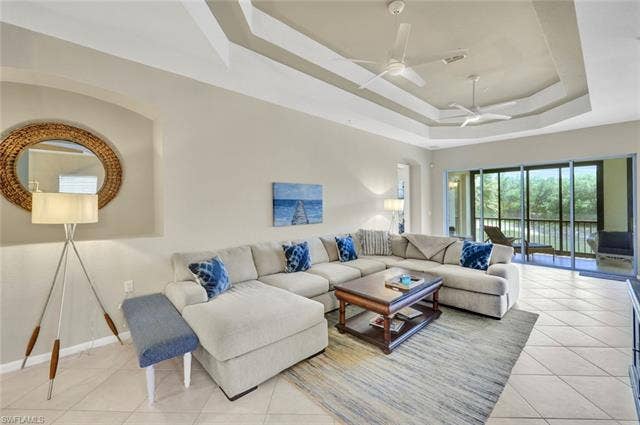 10060 Valiant Ct, #202, Miromar Lakes, FL 33913 Spacious living area featuring a tray ceiling, recessed lighting, and multiple ceiling fans