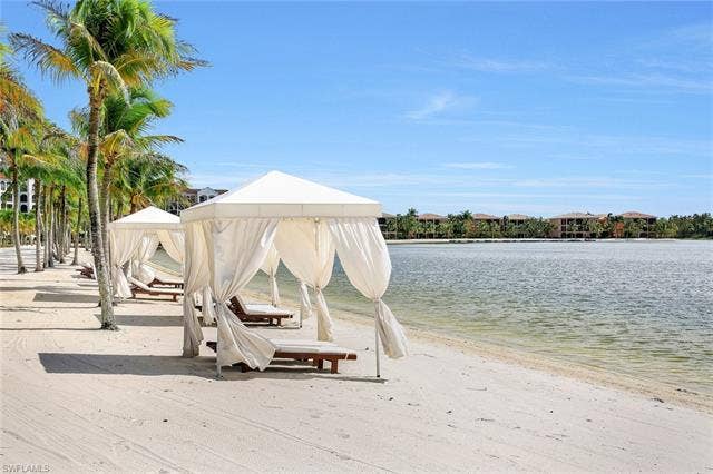 10060 Valiant Ct, #202, Miromar Lakes, FL 33913 Sandy beach area featuring multiple cabanas with white fabric canopies