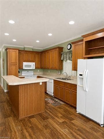 20472 Luettich Ln, Estero, FL 33928 Kitchen featuring wood-finish flooring, recessed ceiling lighting, light-toned countertops, and extensive wood cabinetry with an integrated breakfast bar