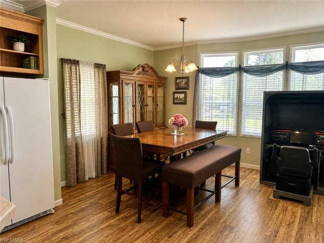 20472 Luettich Ln, Estero, FL 33928 Dining area featuring wood-finish flooring and crown molding