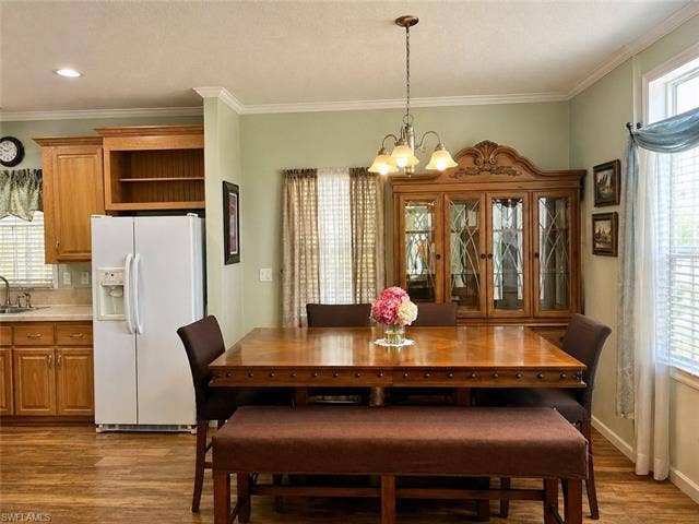 20472 Luettich Ln, Estero, FL 33928 Dining area featuring wood-finish flooring and crown molding