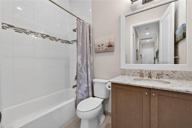 16459 Orinda Way, Bonita Springs, FL 34135 2nd full bath features floor to ceiling tile, wood framed mirror and continuous plank tile flooring.