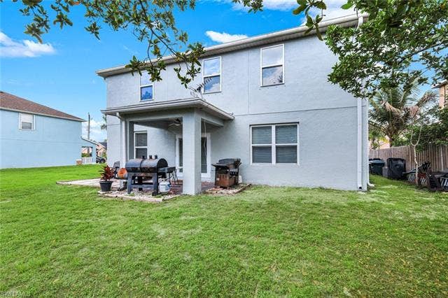 26701 Lincoln Ave, Bonita Springs, FL 34135 Expansive backyard featuring a manicured lawn, a covered patio, and a privacy fence