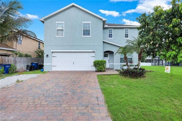 26701 Lincoln Ave, Bonita Springs, FL 34135 Two-story stucco exterior featuring a prominent gable roofline and multiple double-hung windows