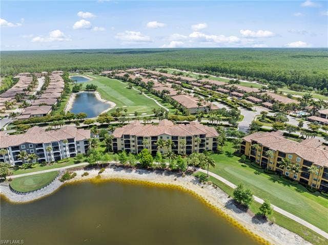 17921 Bonita National Blvd, #244, Bonita Springs, FL 34135 Expansive aerial showcasing a residential community with multiple multi-story buildings featuring terracotta-style roofs, a golf course with manicured greens, multiple water features, and extensive landscaping