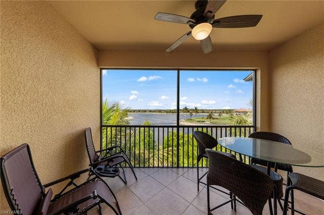 17921 Bonita National Blvd, #244, Bonita Springs, FL 34135 Screened balcony featuring a ceiling fan with integrated lighting, textured walls, and tile flooring
