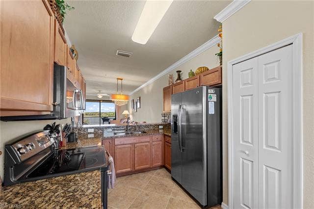 17921 Bonita National Blvd, #244, Bonita Springs, FL 34135 Kitchen featuring wood cabinetry, stainless steel appliances, granite countertops, and tile flooring